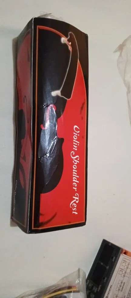 A Violin Shoulder Rest box with the black rest visible in plastic wrap, photographed by Megan R., a verified buyer
